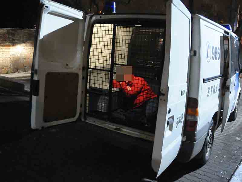 Leżący mężczyzna w przedziale przewozowym radiowozu straży miejskiej