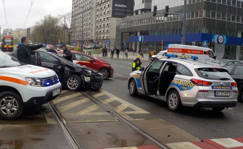 Kolizja przy Grzybowskiej- uszkodzone samochody na jezdni, obok radiowóz straży miejskiej i strażniczka zabezpieczająca miejsce zdarzenia.