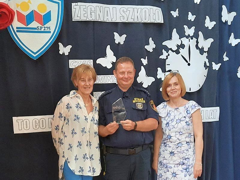 Starszy inspektor Krystian Senkulski z nagrodą w towarzystwie dyrektor szkoły i jednej z nauczycielek