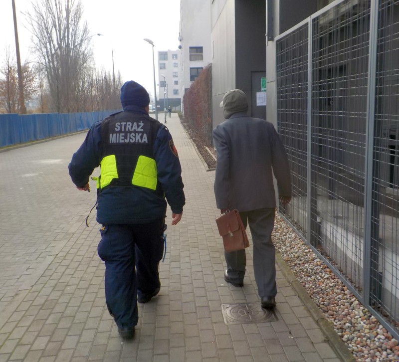 Strażnik miejski wraz z odnalezionym seniorem na chodniku przy osiedlu.