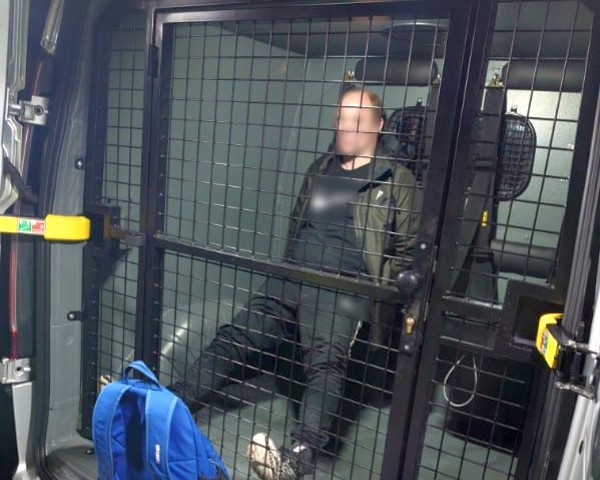 Ujęty mężczyzna zamknięty w przedziale przewozowym radiowozu straży miejskiej