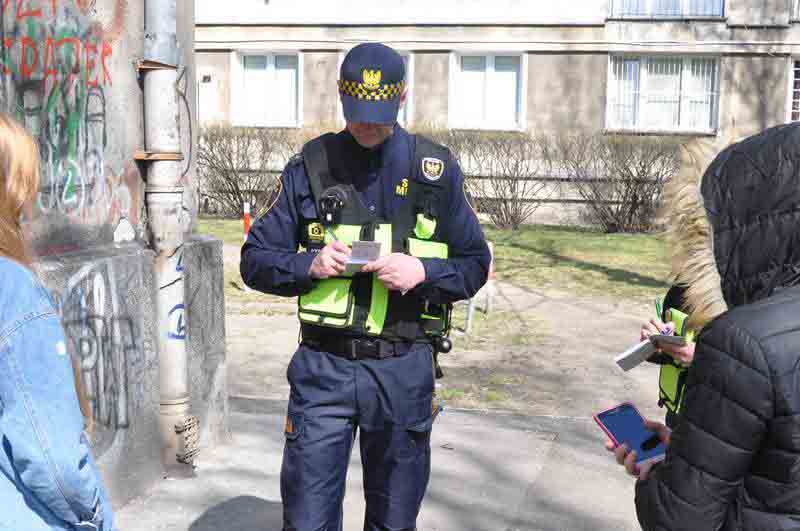 Strażnik miejski legitymujący nieletnich- zdjęcie ilustracyjne