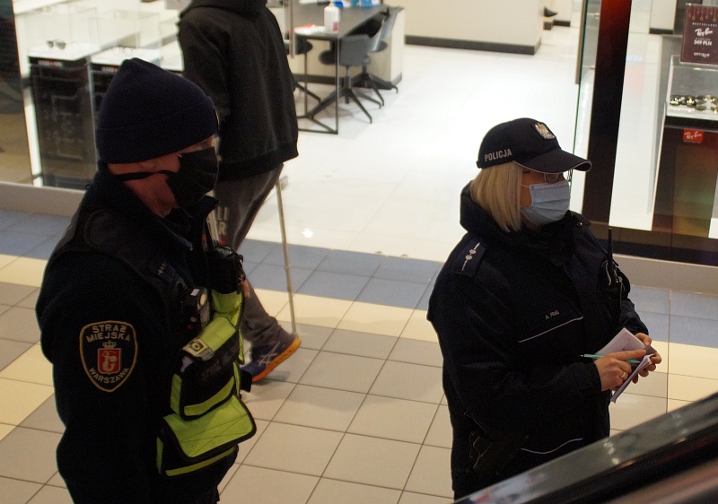 Strażnik miejski i policjantka w centrum handlowym