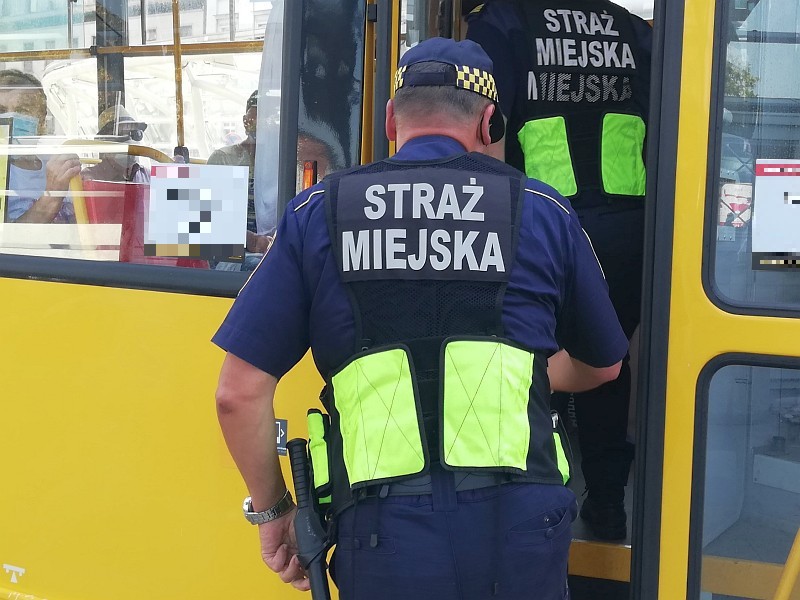 Strażnicy miejscy wchodzący do tramwaju.