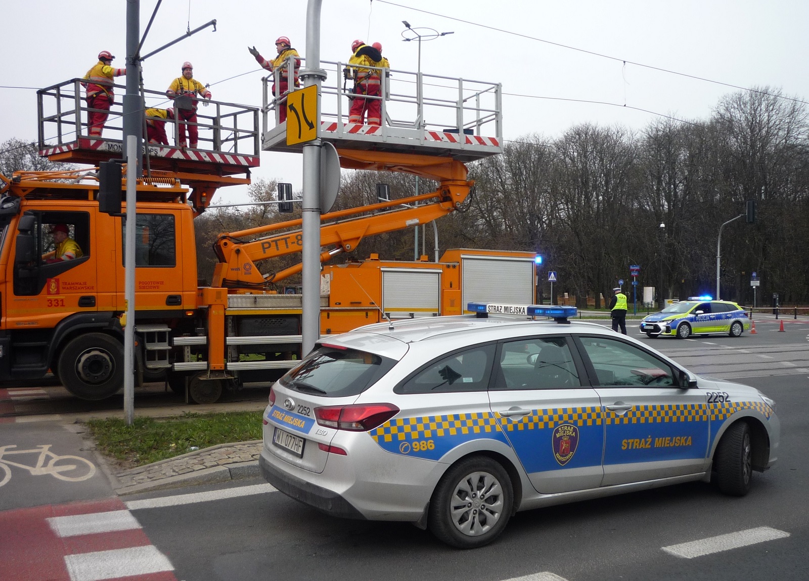Radiowóz straży miejskiej na miejscu naprawy trakcji tramwajowej.