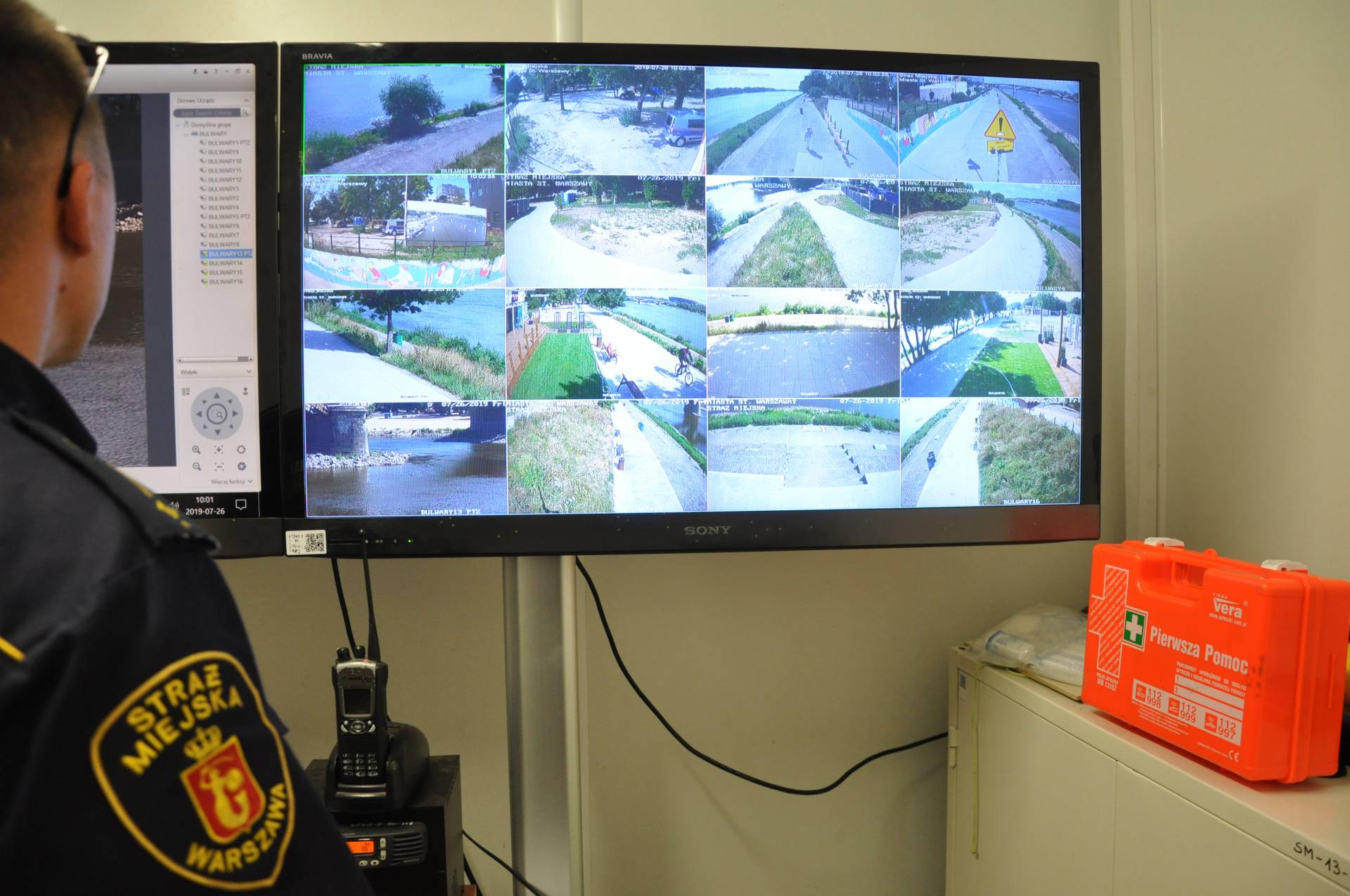 Wnętrze nadwiślańskiego posterunku straży miejskiej. Strażnik operator przegląda obraz z kamer monitoringu.