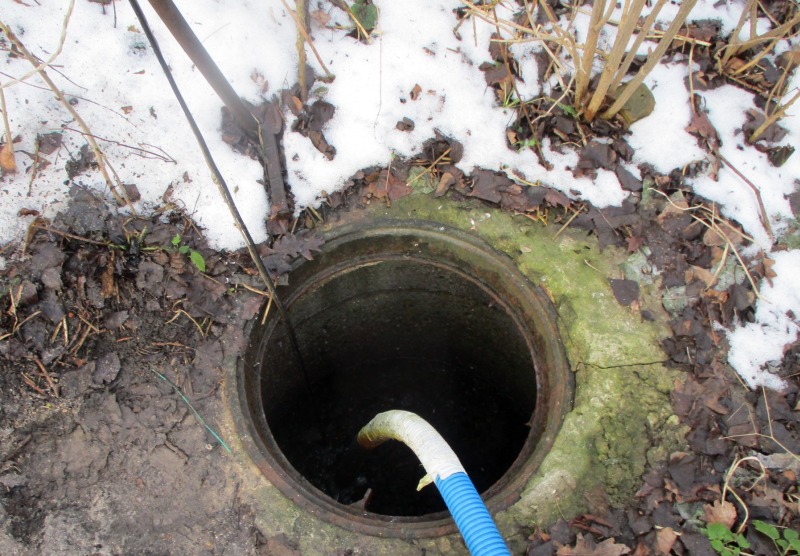 Studzienka kanalizacyjna z wężem odprowadzającym nieczystości na miejscu wykroczenia.