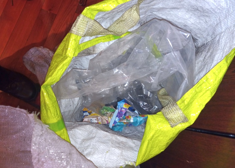Zdjęcie z interwencji: przygotowane do spalenia śmieci w zielonej, plastikowej torbie.