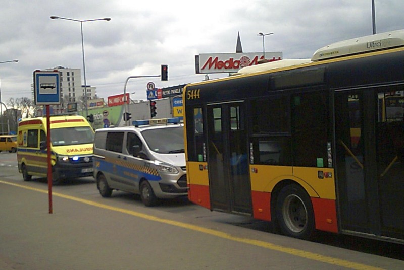 Stojący na przystanku autobus, za nim radiowóz straży miejskiej oraz karetka pogotowia